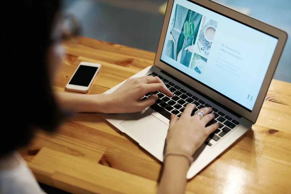 A laptop display shows a coding app with a calculator-style design in a tech office environment.